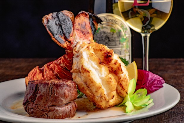Filet and lobster tail plated with a glass of white wine